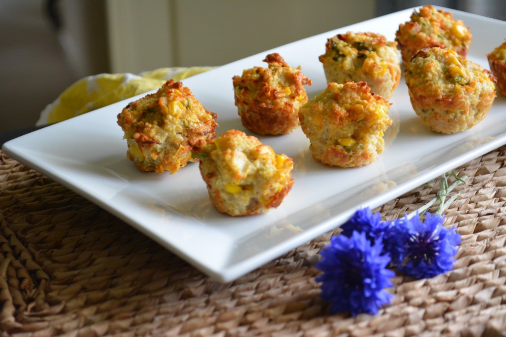 Savoury mini muffins on a white plate with cornflowers in foreground