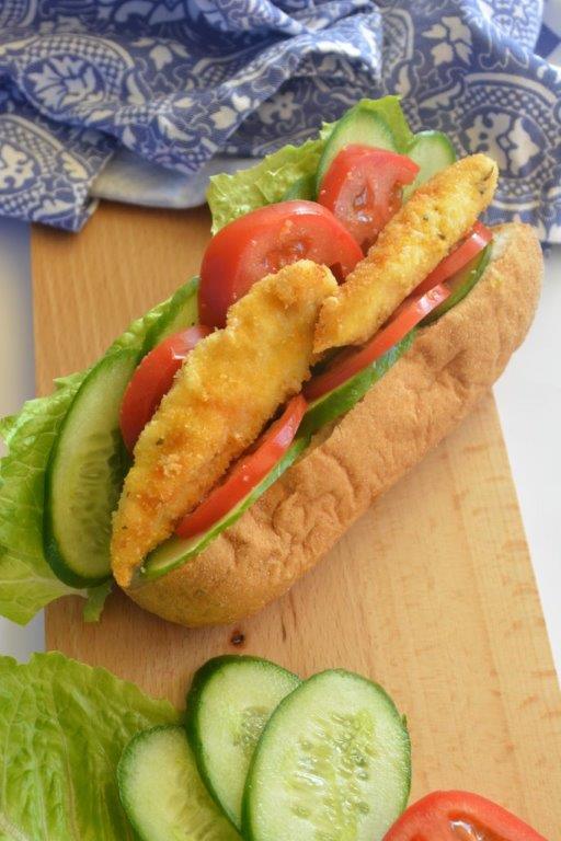 Gluten-free polenta chicken tenders in bread roll with cucumber, tomato and lettuce, representing GFL's top 5 fast-food inspired lunchtime recipes