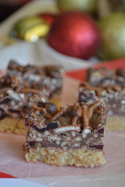 Gluten-free Christmas chocolate cranberry slice with red and gold decorations in background. GFL's best gluten-free Christmas recipes