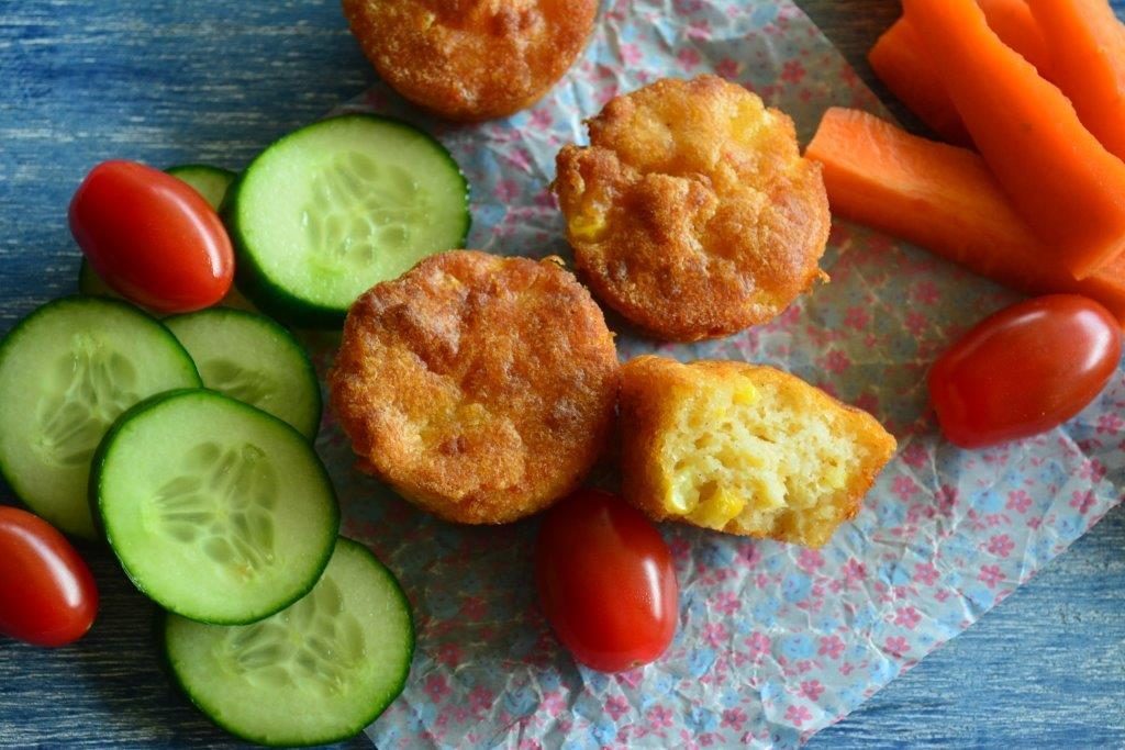Gluten-free cheese and corn puffs with cucumber, cherry tomatoes and carrot sticks