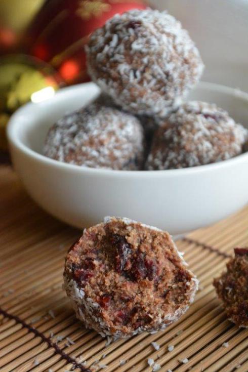 Gluten-free no bake balls in a bowl with broken ball in foreground