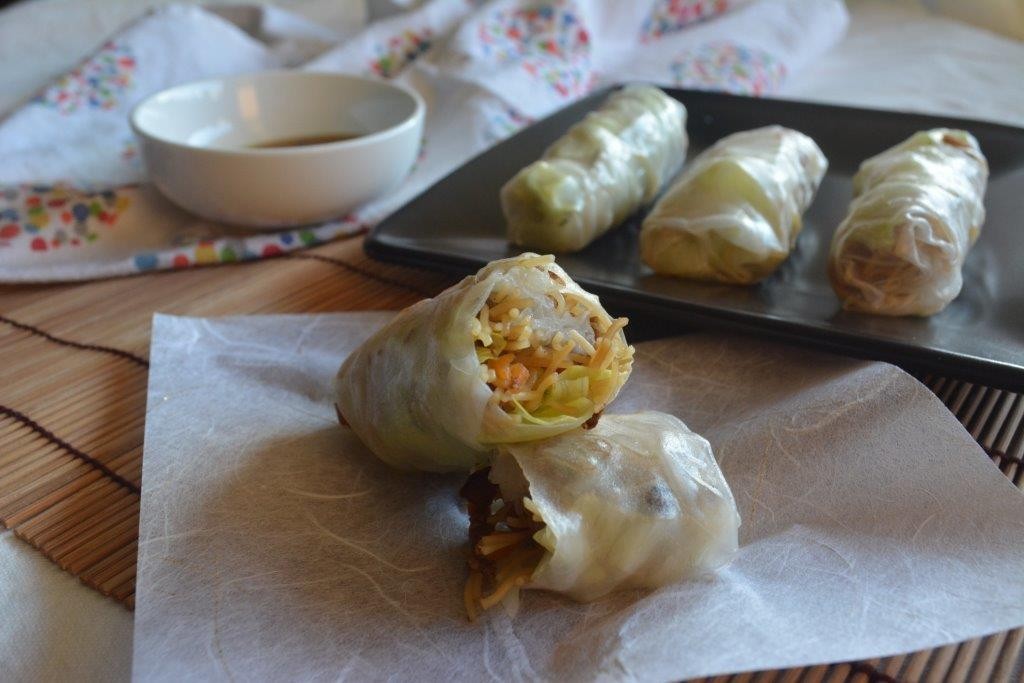 Gluten-free cold rolls on parchment with cold rolls and dipping sauce in background. Top 10 gluten-free lunch recipes.